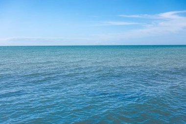 Deniz suyu ve beyaz bulutlu mavi gökyüzü. Doğa bileşimi.