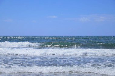 Kumsalda deniz dalgaları. Güzel deniz manzarası. Panorama. Mavi deniz ve mavi gökyüzü arka planı. Yaz denizi ve mavi gökyüzü.