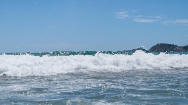 Kumsalda deniz dalgaları. Güzel deniz manzarası. Panorama. Mavi deniz ve mavi gökyüzü arka planı. Yaz denizi ve mavi gökyüzü.