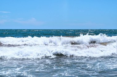 Kumsalda deniz dalgaları. Güzel deniz manzarası. Panorama. Mavi deniz ve mavi gökyüzü arka planı. Yaz denizi ve mavi gökyüzü.