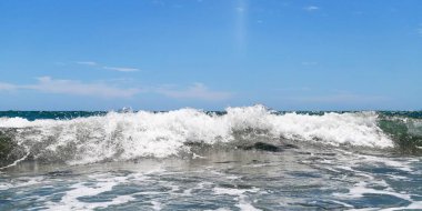 Kumsalda deniz dalgaları. Güzel deniz manzarası. Panorama. Mavi deniz ve mavi gökyüzü arka planı. Yaz denizi ve mavi gökyüzü.