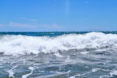 Kumsalda deniz dalgaları. Güzel deniz manzarası. Panorama. Mavi deniz ve mavi gökyüzü arka planı. Yaz denizi ve mavi gökyüzü.