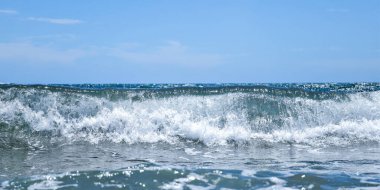 Kumsalda deniz dalgaları. Güzel deniz manzarası. Panorama. Mavi deniz ve mavi gökyüzü arka planı. Yaz denizi ve mavi gökyüzü.
