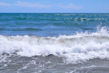 Kumsalda deniz dalgaları. Güzel deniz manzarası. Panorama. Mavi deniz ve mavi gökyüzü arka planı. Yaz denizi ve mavi gökyüzü.