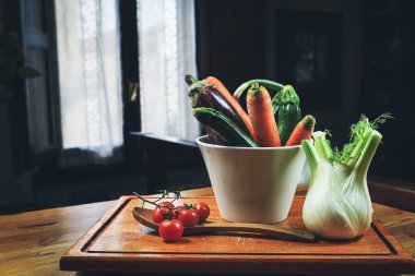 Mutfaktaki ahşap masada salata için taze sebzeler..