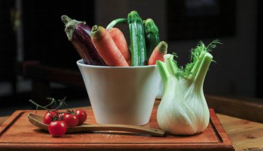 Tahta kasede taze sebzeler ve baharatlar.