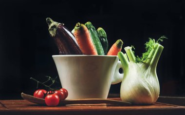 Koyu bir arka planda pişirmek için taze organik sebzeler