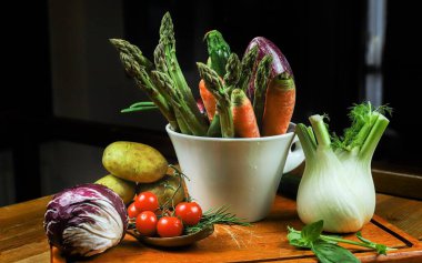 Taze sebze ve otlar ahşap bir masa üzerinde.