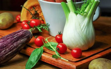 Tahta masada kırmızı soğan ve diğer sebzeler.