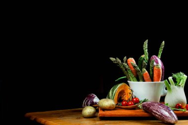 Siyah ahşap bir masada taze sebzeler.