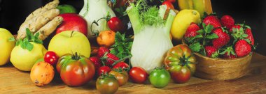 Masadaki tahta sandıkta sebzeler.