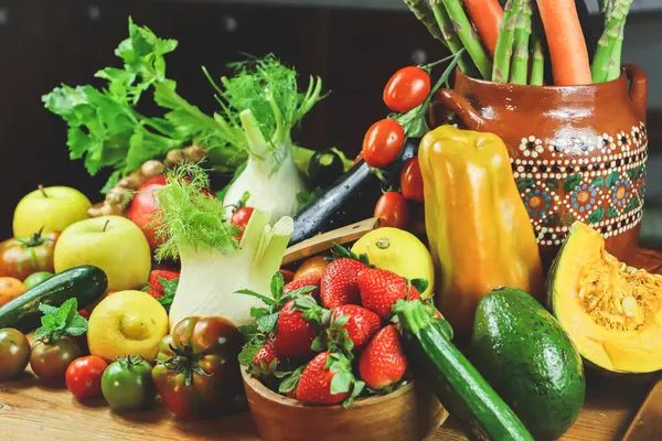 Ahşap zemin üzerinde çeşitli organik sebzeler ve mutfak meyveleri olan bir kompozisyon. diyet ve sağlıklı gıda konsepti
