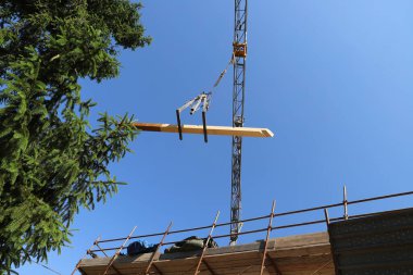 Mavi gökyüzünün arka planında inşaat vinci ve binası