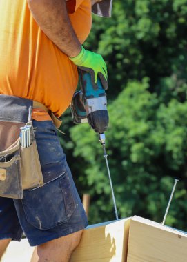 Üniformalı inşaat işçisi elinde matkapla