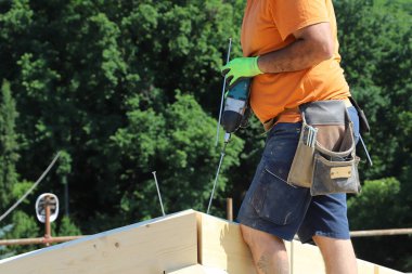 Koruyucu miğferli ve tahta eldivenli bir adam.