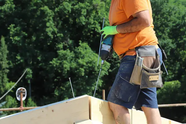 Koruyucu miğferli ve tahta eldivenli bir adam.