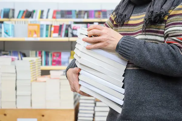 Adam kütüphanede kitap okuyor, kitap okuyor.