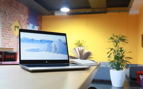 Arka planda ofis masası olan dizüstü bilgisayar