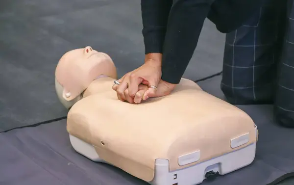 Sağlık odasında ilk yardım eğitimi alan bir adam..