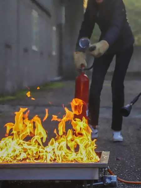 Yanan ateşle yangın söndürücü. şirket güvenliği - itfaiye kursu sırasında egzersiz