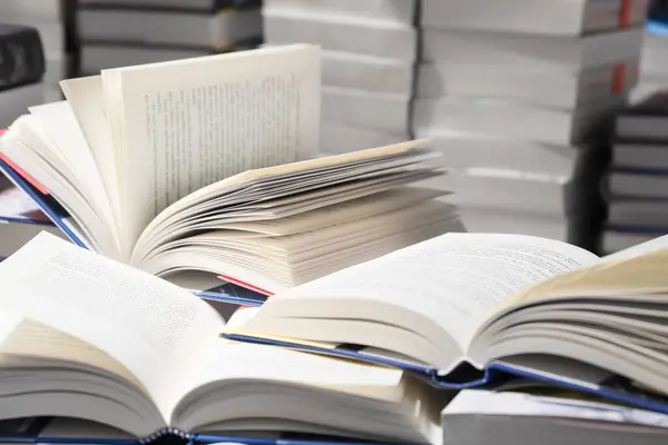 Kitap yığını, kapatın. Kütüphanede masanın üzerinde açık bir kitap. Okul konseptine dönelim..