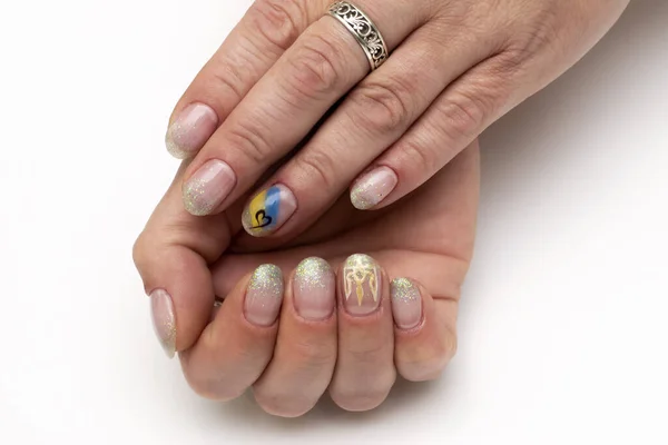 Mint glitter on short oval nails. Patriotic manicure. Yellow-blue drawing. Close-up on a white background