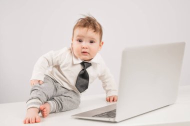 Dizüstü bilgisayarda çalışan kravatlı yakışıklı bir çocuk.