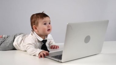 Dizüstü bilgisayarda çalışan kravatlı yakışıklı bir çocuk.