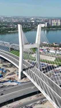 Şehirdeki bir nehirden geçen kablo destekli yol köprüsünün havadan görüntüsü.