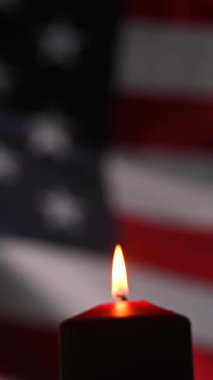 Amerika Birleşik Devletleri 'nin bayrağını sallayan arka planda yanan mum.