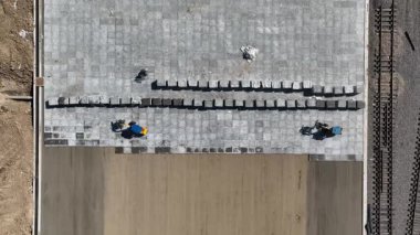 Yükleyiciler döşeme döşemeleri döşüyorlar. Bir İHA görüntüsü