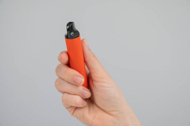 Beyaz arka planda tek kullanımlık bir yelek tutan kadın. Boşluğu kopyala