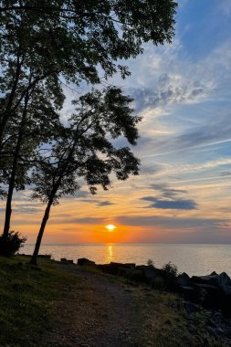 Gölün üzerinde gün batımında ağaç siluetleriyle. Güzel yaz manzarası. Gölde Niagara