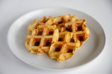 Beyaz tabakta peynirli Belçika waffleları. Yakın plan..