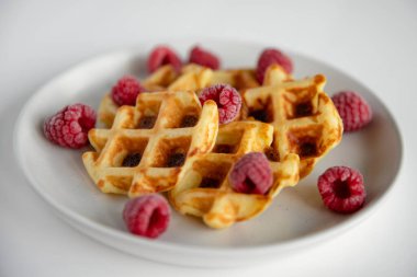 Beyaz tabakta ahududulu waffle. Seçici odak.