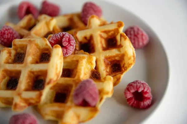 Beyaz tabakta ahududulu waffle. Seçici odak.