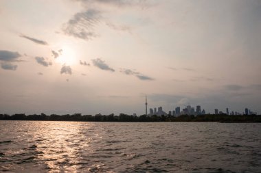 Gökyüzünde bulutlarla gölün üzerinde gün batımı. Akşam manzarası. Toronto Adası, Kanada Manzarası.