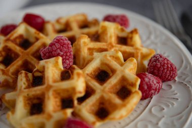 Ahududulu waffle. Tabağında ahududu olan lezzetli waffle 'lar, yakın plan..