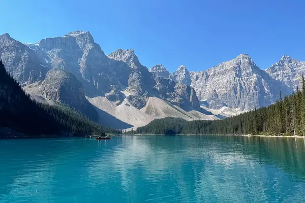 Sabah Moraine Gölü 'ndeki dağlara giden bir tekneden manzara. Moraine Gölü, Banff.