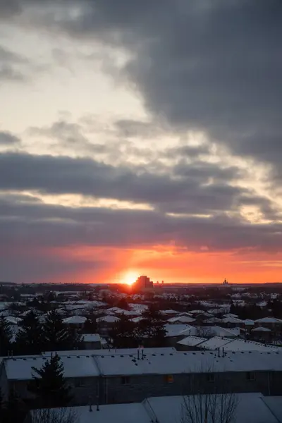 Kışın çatılarda gün doğumu. Kanada.