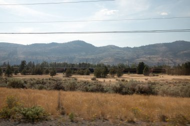 Kırsal kesimdeki yol ve demiryolu manzarası var. Kamloops, Kanada.