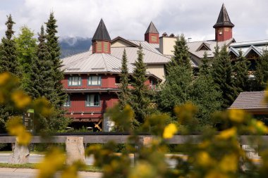 Dağların arkasına kurulmuş ahşap evler ve mavi bir gökyüzü. Whistler, BC, Kanada.