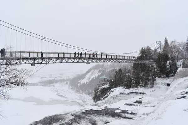 Quebec, Kanada - 31 Aralık 2019: Nehir üzerindeki köprünün kış manzarası karla kaplı resimli bir manzara. 