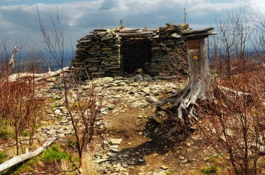 A hill top of Srebrna Kopa with bothy building with stones on the cloudy day on the beginning of spring (taken in Opava Mountains, Gry Opawskie) clipart