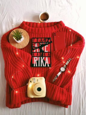 Örgü süveter ve bir fincan çay ile ahşap bir arka planda bir eşarp. Noel ve Yeni Yıl Günü.
