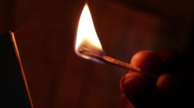 Karanlık odadaki kibrit çöpünü yakın çekim makrosu. Orijinal görüntü. Renk derecelendirme yok, yavaş çekim yok..