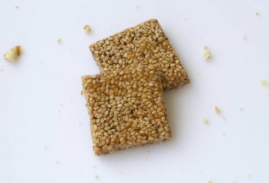 Beyaz arka planda Til Chikki. Til chikki jaggery ve susamlı bir Hint tatlısıdır. Hint festivali makar battı özel tatlı.