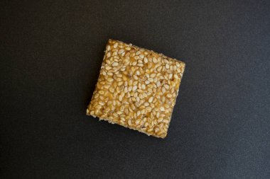 Siyah desenli arka plan üzerine Til Chikki. Til chikki jaggery ve susamlı bir Hint tatlısıdır. Hint festivali makar battı özel tatlı.