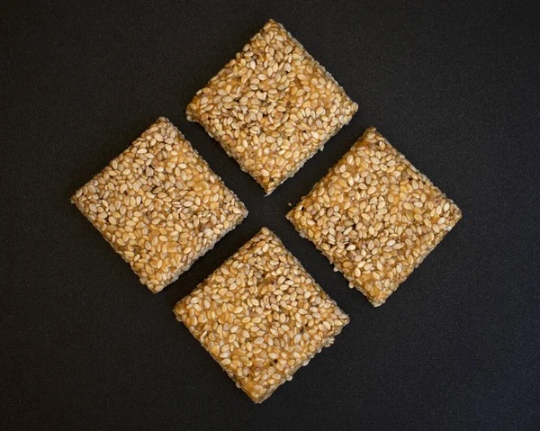 Siyah desenli arka plan üzerine Til Chikki. Til chikki jaggery ve susamlı bir Hint tatlısıdır. Hint festivali makar battı özel tatlı.