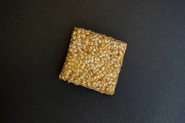 Siyah desenli arka plan üzerine Til Chikki. Til chikki jaggery ve susamlı bir Hint tatlısıdır. Hint festivali makar battı özel tatlı.